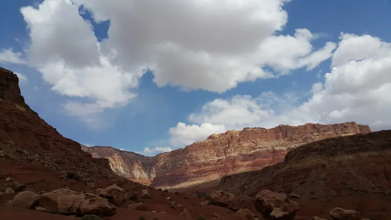 Vermilion Cliff Road 옆에 있는 붉은색 절벽이 보이며 위에는 뭉개구름이 떠 있음