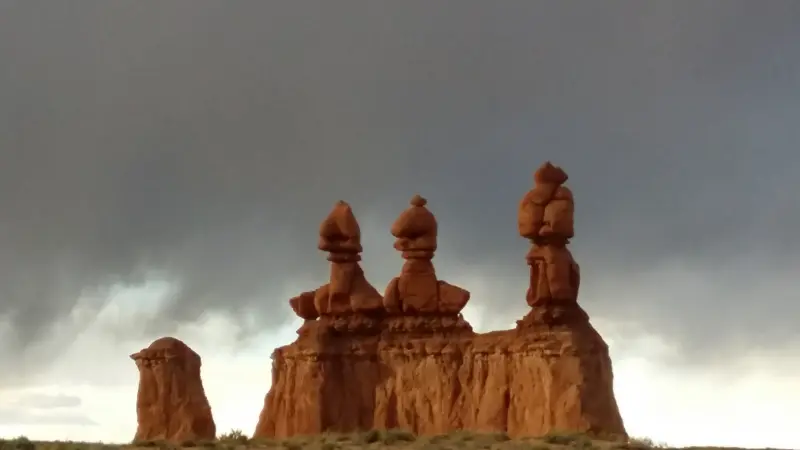Goblin Valley State Park의 세자매가 보이는데 멀리 후두 3개가 절벽위에 서 있음
